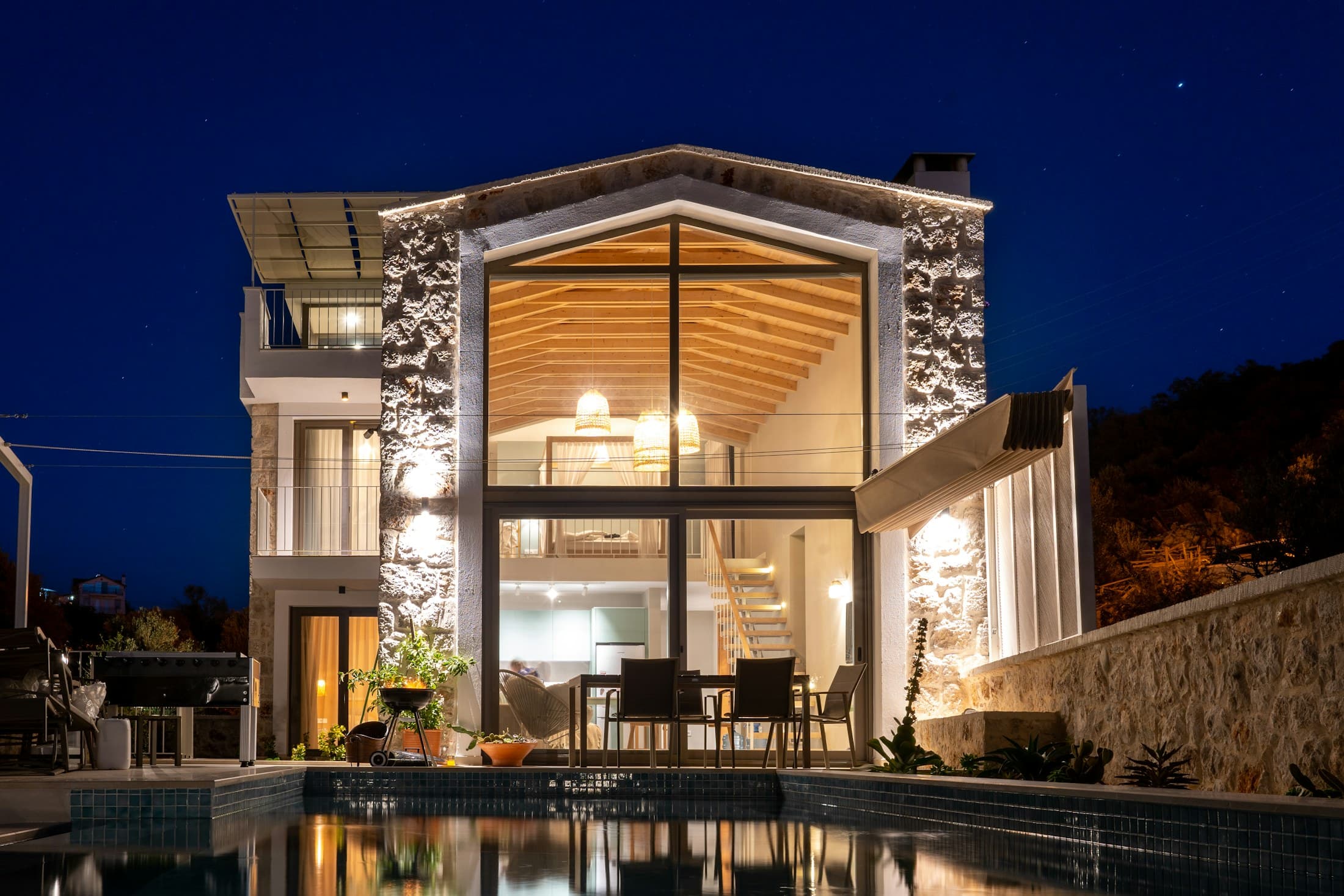 Residencia con muros de vidrio y piscina al atardecer